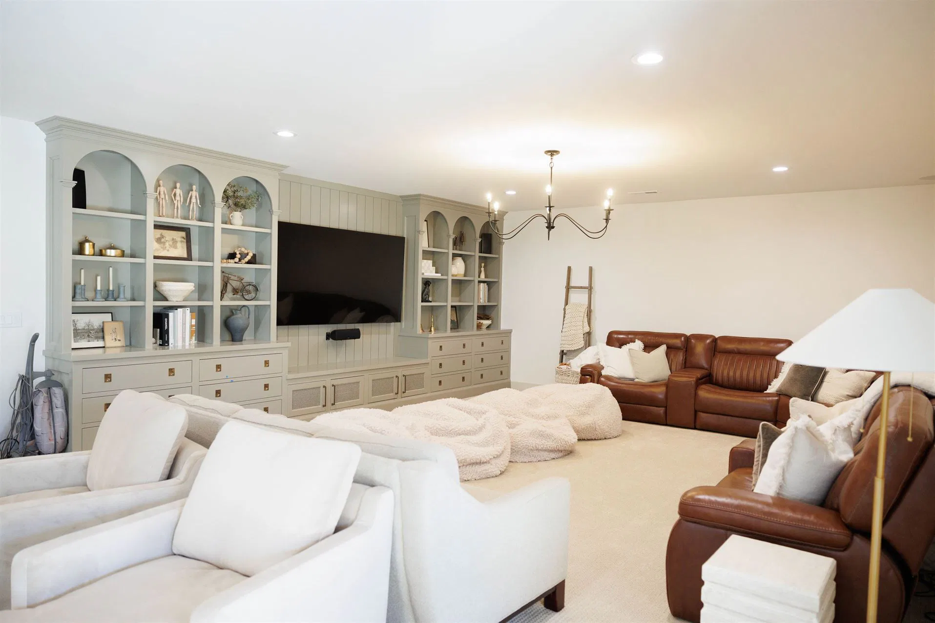 A living room featuring couches, chairs, and a television, designed with a Crown Finish for an elegant touch.